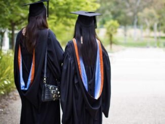Graduates walking in gowns and caps.
