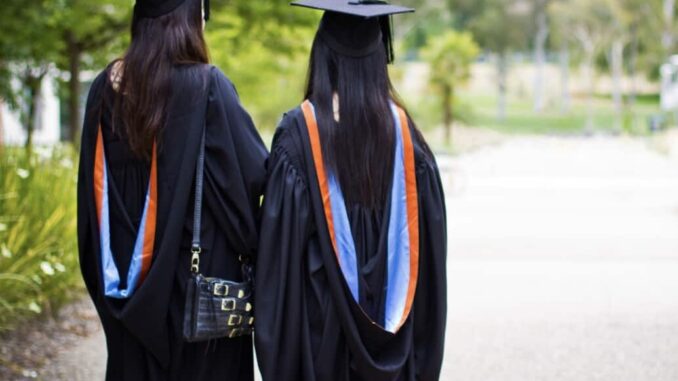 Graduates walking in gowns and caps.