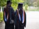 Graduates walking in gowns and caps.