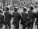 Soldiers facing crowd during protest.