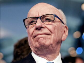 Elderly man wearing glasses, looking upwards.