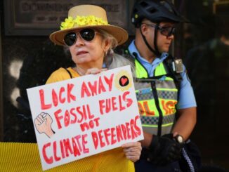 Protester holding sign against fossil fuels.