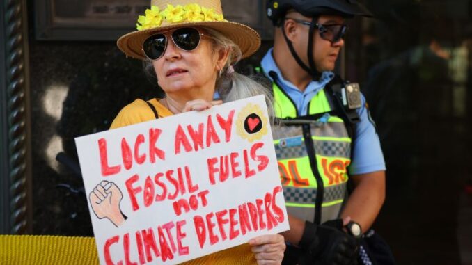 Protester holding sign against fossil fuels. Protester holding sign against fossil fuels.