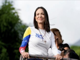 Woman in colorful shirt outdoors, smiling confidently.