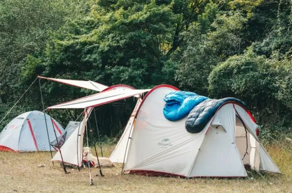 Camping tents with sleeping bag in forest.