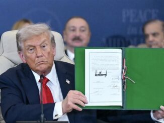 Man displaying signed document at event.