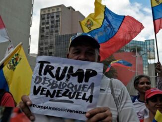 Protesters holding signs and Venezuelan flags.
