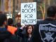 Protester holding "No Room for Racism" sign.