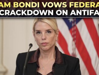 Woman speaking, U.S. flag background, announcement headline.