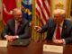 Two men sitting at a conference table.