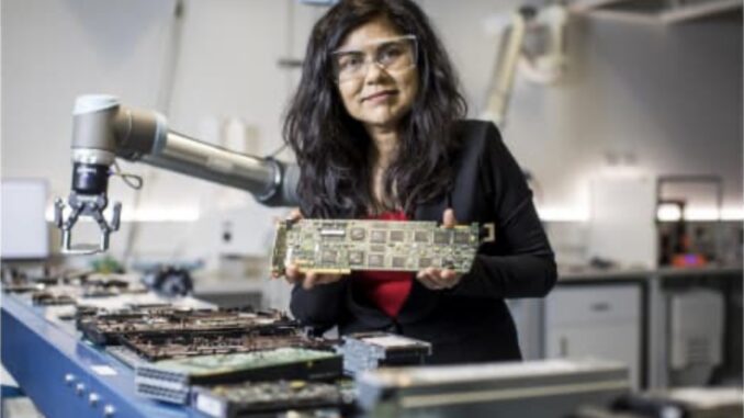 Woman holding circuit board in a laboratory.