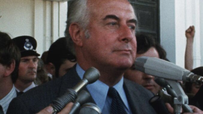 Man speaking at microphones, surrounded by crowd. Man speaking at microphones, surrounded by crowd.