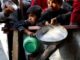 Children holding empty plates and containers.