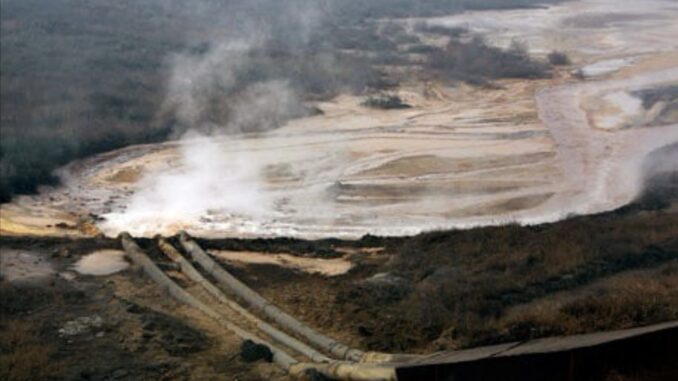 Polluted river with pipes and steam.