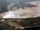 Polluted river with pipes and steam.