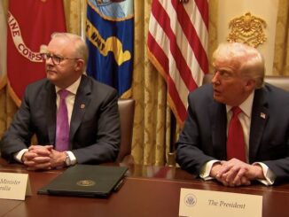 Two officials seated at a conference table.