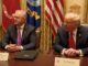 Two officials seated at a conference table.