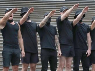 Group of people in black clothing, saluting.