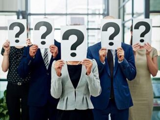 People holding question mark signs over faces.