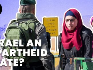 Israeli soldier and two women at barrier.