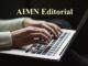 Hands typing on laptop under "AIMN Editorial