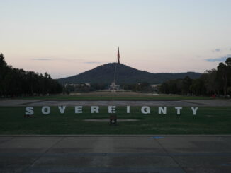 Sovereignty sign with mountain and flag background.