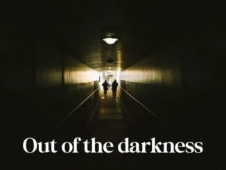 Silhouettes walking towards light in tunnel.