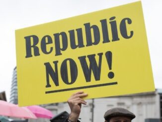 Protester holding "Republic NOW!" sign outdoors.