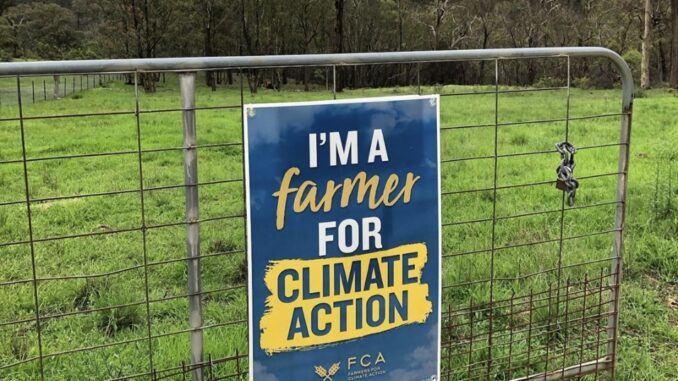 Sign on gate: "I'm a Farmer for Climate Action.