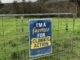 Sign on gate: "I'm a Farmer for Climate Action.