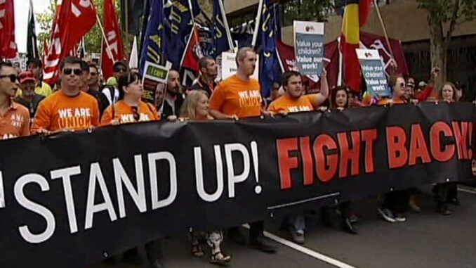 Protesters holding "Stand Up! Fight Back!" banner.