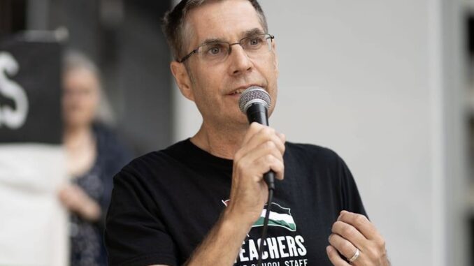 Man speaking into microphone, wearing black shirt. Man speaking into microphone, wearing black shirt.