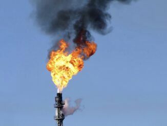 Industrial gas flare with black smoke.