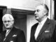 Two men in suits, black and white photo.