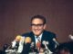 Smiling man speaking at a press conference.
