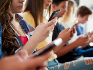 People sitting, using smartphones together.