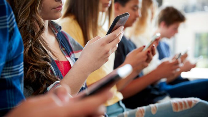 People sitting, using smartphones together.