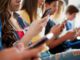 People sitting, using smartphones together.