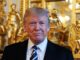 Man in suit with golden statues background.