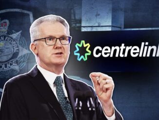 Man speaking, Centrelink logo in background.