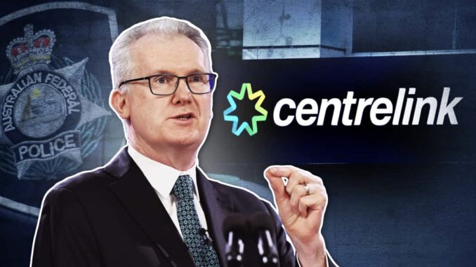 Man speaking, Centrelink logo in background.