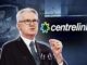 Man speaking, Centrelink logo in background.