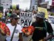 Protesters holding "Make Polluters Pay" signs.
