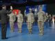 Military personnel taking an oath on stage.