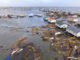 Flooded coastal village with scattered houses.