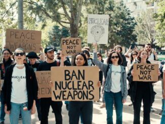 Protesters holding signs against nuclear weapons.