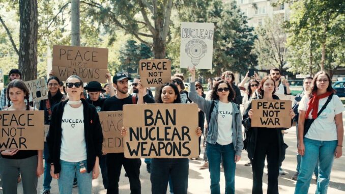 Protesters holding signs against nuclear weapons.