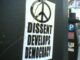 Sticker with peace sign and democracy message.