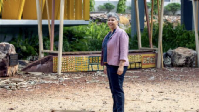 Person standing near a colorful structure outside. Person standing near a colorful structure outside.