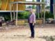 Person standing near a colorful structure outside.